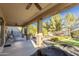 A grand covered patio with ceiling fans overlooking a manicured lawn and outdoor dining space at 549 W Sweet Shrub Ave, Queen Creek, AZ 85140