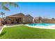 Beautiful backyard with pool, manicured lawn, and a covered patio for outdoor living at 6526 W West Wind Dr, Glendale, AZ 85310