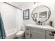 This updated bathroom is stylish and functional with a modern vanity, sleek mirror, and bathtub with shower at 6526 W West Wind Dr, Glendale, AZ 85310