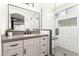 This modern bathroom is light and airy with updated fixtures, a glass shower, and a stylish sink and vanity at 6526 W West Wind Dr, Glendale, AZ 85310