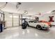 Spacious three car garage featuring epoxy floors, recessed lighting, and an automobile lift at 6526 W West Wind Dr, Glendale, AZ 85310