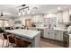 Open-concept kitchen with white cabinets, island with barstool seating, and adjacent living area at 6526 W West Wind Dr, Glendale, AZ 85310