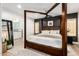 This spacious bedroom features a four-poster bed, modern decor, and an en suite bathroom for added privacy and convenience at 6526 W West Wind Dr, Glendale, AZ 85310
