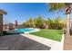 Backyard pool features a waterslide, lush landscaping, and a manicured lawn at 6526 W West Wind Dr, Glendale, AZ 85310
