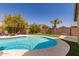 Backyard pool with mountain views, lush landscaping, and a stone privacy wall at 6526 W West Wind Dr, Glendale, AZ 85310