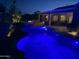 Nighttime view of a sparkling blue pool and hot tub, with a fire pit and outdoor seating area at 6751 S Callaway Dr, Chandler, AZ 85249