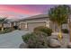 Home exterior showcasing xeriscaping, decorative rock and mature trees at twilight at 6751 S Callaway Dr, Chandler, AZ 85249