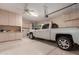 Spacious three car garage with white walls, a truck, ceiling fan, and storage cabinets at 6751 S Callaway Dr, Chandler, AZ 85249