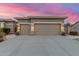 Front exterior showing a three car garage, lighting, and beautiful sky at dusk at 6751 S Callaway Dr, Chandler, AZ 85249