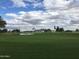 Expansive golf course view with a pond, green fairway, and mountain backdrop under a cloudy sky at 6751 S Callaway Dr, Chandler, AZ 85249