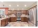 Well-equipped kitchen featuring stainless steel appliances, wooden cabinetry, and tiled backsplash at 6751 S Callaway Dr, Chandler, AZ 85249