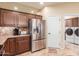 Kitchen showcasing stainless steel refrigerator, ample cabinetry, and access to laundry room at 6751 S Callaway Dr, Chandler, AZ 85249