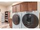 Laundry room with washer, dryer, cabinets, folding table, and marble floors at 6751 S Callaway Dr, Chandler, AZ 85249