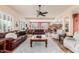 Bright living room featuring leather sofas, a ceiling fan, and access to the kitchen area at 6751 S Callaway Dr, Chandler, AZ 85249