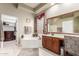 Main bathroom featuring a soaking tub, spacious vanity, and a walk-in closet at 6751 S Callaway Dr, Chandler, AZ 85249