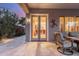 Inviting covered patio with comfortable seating and view into the home's interior at dusk at 6751 S Callaway Dr, Chandler, AZ 85249