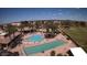 Aerial view of community pools with lounge chairs and palm trees near the golf course at 6751 S Callaway Dr, Chandler, AZ 85249