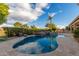 Freeform pool featuring lush landscaping, spa and a stone firepit creating an ideal space for relaxation at 6751 S Callaway Dr, Chandler, AZ 85249