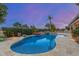 Backyard with pool, stone waterfall, desert landscaping and outdoor lighting at dusk at 6751 S Callaway Dr, Chandler, AZ 85249
