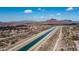 Scenic aerial view of a community near a canal with beautiful mountain scenery in the backdrop at 6929 E Trailridge Cir, Mesa, AZ 85207