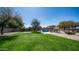 Expansive backyard with a pool, manicured lawn, seating area, and lush landscaping, perfect for outdoor living at 6929 E Trailridge Cir, Mesa, AZ 85207