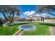 Expansive backyard featuring lush green grass, a trampoline, and a sparkling pool at 6929 E Trailridge Cir, Mesa, AZ 85207