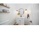 Powder room featuring a stylish vanity, round mirror, and open shelving at 6929 E Trailridge Cir, Mesa, AZ 85207