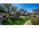 Attractive home with a well-manicured lawn, mature trees, and a three-car garage at 6929 E Trailridge Cir, Mesa, AZ 85207