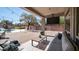 Relaxing covered patio with plush seating, television, overlooking a backyard pool and manicured lawn at 6929 E Trailridge Cir, Mesa, AZ 85207