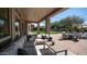 Inviting covered patio with comfortable sectional, string lights, and view of the landscaped yard and pool at 6929 E Trailridge Cir, Mesa, AZ 85207