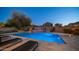 Backyard pool at night featuring a tanning deck, slide, diving board, and lounge chairs under a clear night sky at 6929 E Trailridge Cir, Mesa, AZ 85207
