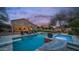 Twilight view of a backyard with string lights, pool, and a relaxing spa at 6929 E Trailridge Cir, Mesa, AZ 85207