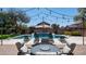 Beautiful backyard with a sparkling pool, lush landscaping, and comfortable seating area with string lights at 6929 E Trailridge Cir, Mesa, AZ 85207