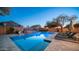 Backyard pool features a slide and a waterfall, and lounge chairs, reflecting the hues of a desert sunset at 6929 E Trailridge Cir, Mesa, AZ 85207