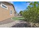 Landscaped backyard with lush greenery, artificial turf, and a winding brick pathway for relaxed outdoor living at 7115 E Olla Ave, Mesa, AZ 85212
