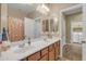 Bright bathroom featuring a double sink vanity with a large mirror and views to another bathroom at 7115 E Olla Ave, Mesa, AZ 85212