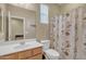 Cozy bathroom with a floral shower curtain, a window, toilet, and a single-sink vanity at 7115 E Olla Ave, Mesa, AZ 85212