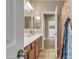 Bright bathroom featuring a double sink vanity with a large mirror and views to laundry room at 7115 E Olla Ave, Mesa, AZ 85212