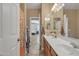 Bright bathroom featuring a double sink vanity with a large mirror and views to a bedroom at 7115 E Olla Ave, Mesa, AZ 85212