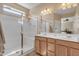 Bright bathroom featuring a glass enclosed shower, and double sink vanity with wood cabinets at 7115 E Olla Ave, Mesa, AZ 85212