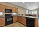 Open kitchen with granite countertops, dark appliances, and warm wood cabinetry at 7115 E Olla Ave, Mesa, AZ 85212