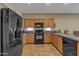 Updated kitchen showcasing dark appliances, granite countertops and warm wood cabinetry at 7115 E Olla Ave, Mesa, AZ 85212