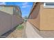 Well-kept side yard with a paved walkway, mature vegetation and secure fencing for privacy and functionality at 7115 E Olla Ave, Mesa, AZ 85212