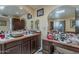Bathroom with a marble countertop, marble sink, framed mirrors, and dark wood cabinets at 7131 E Cholla St, Scottsdale, AZ 85254