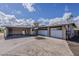 Exterior angle featuring a two-car garage, carport, and neutral color palette under a bright, cloudy sky at 7131 E Cholla St, Scottsdale, AZ 85254
