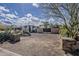A unique desert landscape home with a private gated driveway, mature trees, and tasteful stone accents at 7131 E Cholla St, Scottsdale, AZ 85254