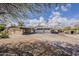 Charming single-Gathering home featuring a long driveway, a two-car garage, and desert landscaping with palm trees at 7131 E Cholla St, Scottsdale, AZ 85254