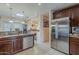 Spacious kitchen with stainless steel appliances, dark wood cabinets, tile floors, and ample counter space at 7131 E Cholla St, Scottsdale, AZ 85254