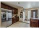 Kitchen with stainless steel refrigerator, dark wood cabinets, and tile flooring at 7131 E Cholla St, Scottsdale, AZ 85254