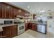 Well-equipped kitchen featuring dark wood cabinetry, stainless steel appliances, granite countertops, and tile flooring at 7131 E Cholla St, Scottsdale, AZ 85254